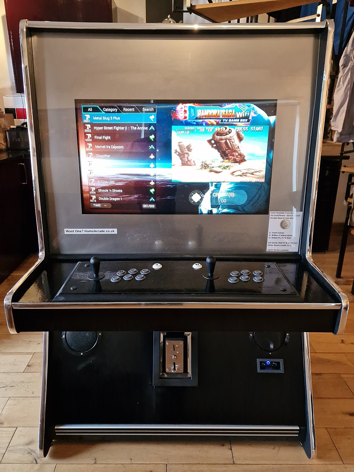 Sit-down arcade cabinet in gloss black with polished chrome trim, two-player control deck and coin mech