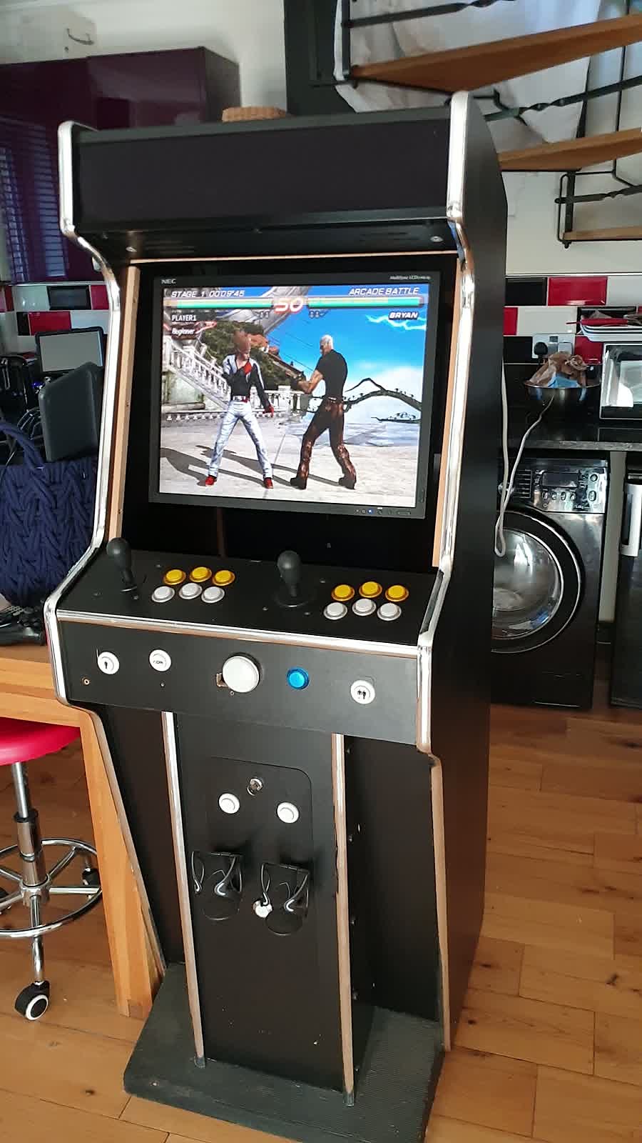Full-height stand-up arcade cabinet with T-mold edging, two-player control deck and pedestal base